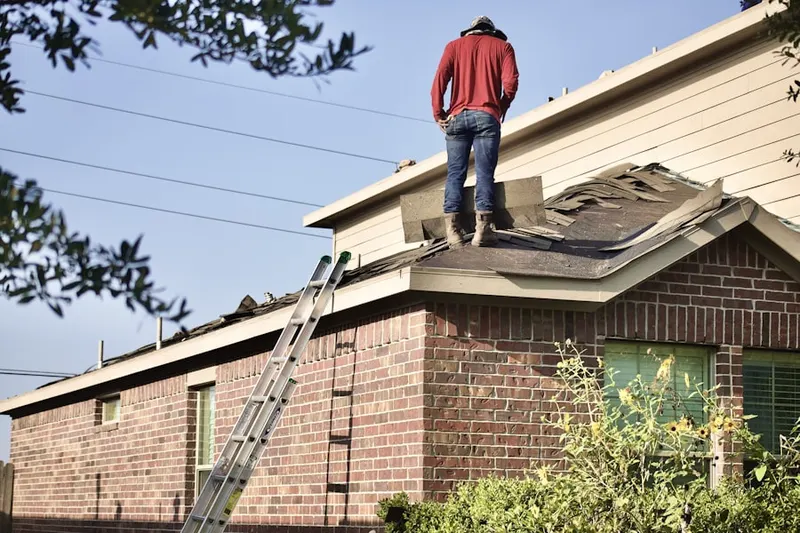 Professional roofer working on a residential roof in Pepperidge